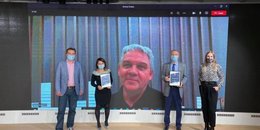 Two women and two men standing infront of screen with Andrej Orožen